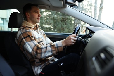 Photo of Driver behind steering wheel of modern car