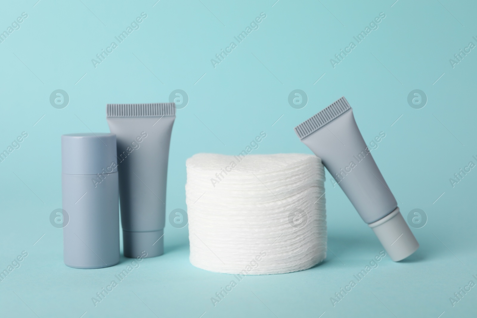 Photo of Clean cotton pads and cosmetic products on light blue background