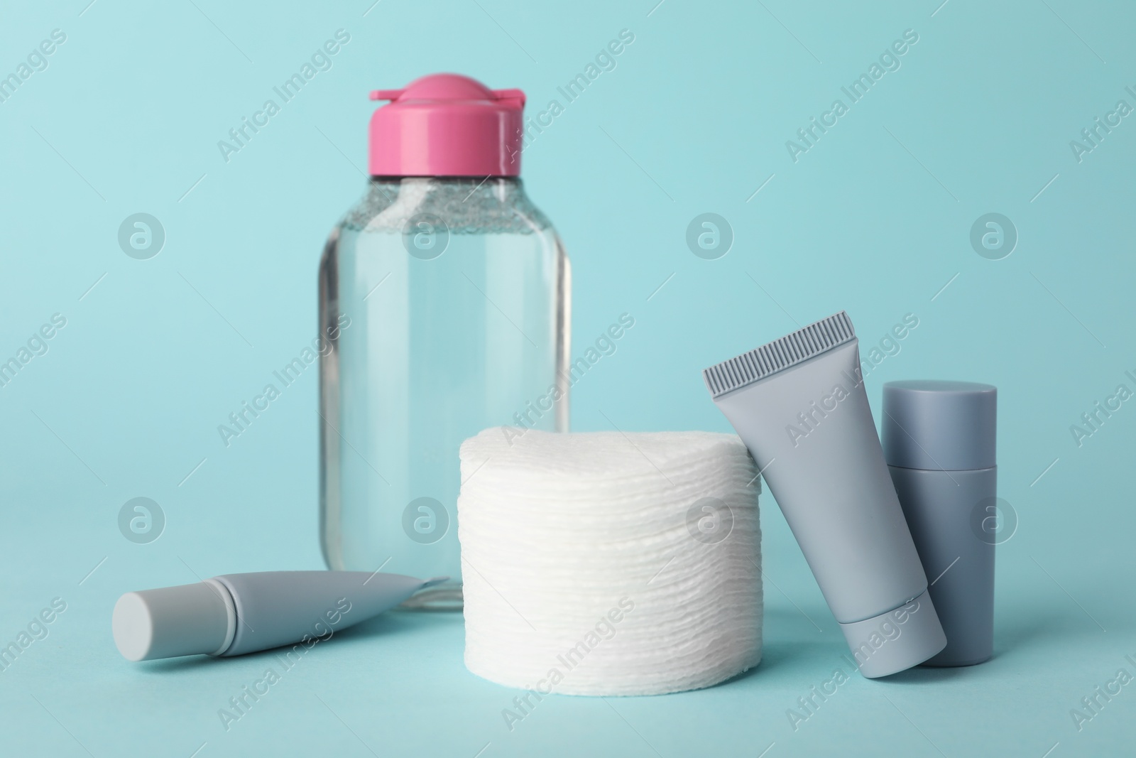 Photo of Clean cotton pads and cosmetic products on light blue background