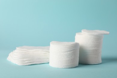 Photo of Clean cotton pads on light blue background, closeup. Space for text