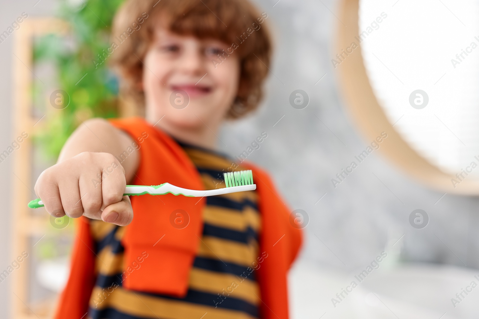 Photo of Cute boy with toothbrush in bathroom, selective focus