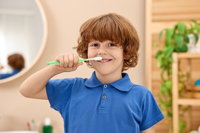 Photo of Cute boy brushing his teeth at home