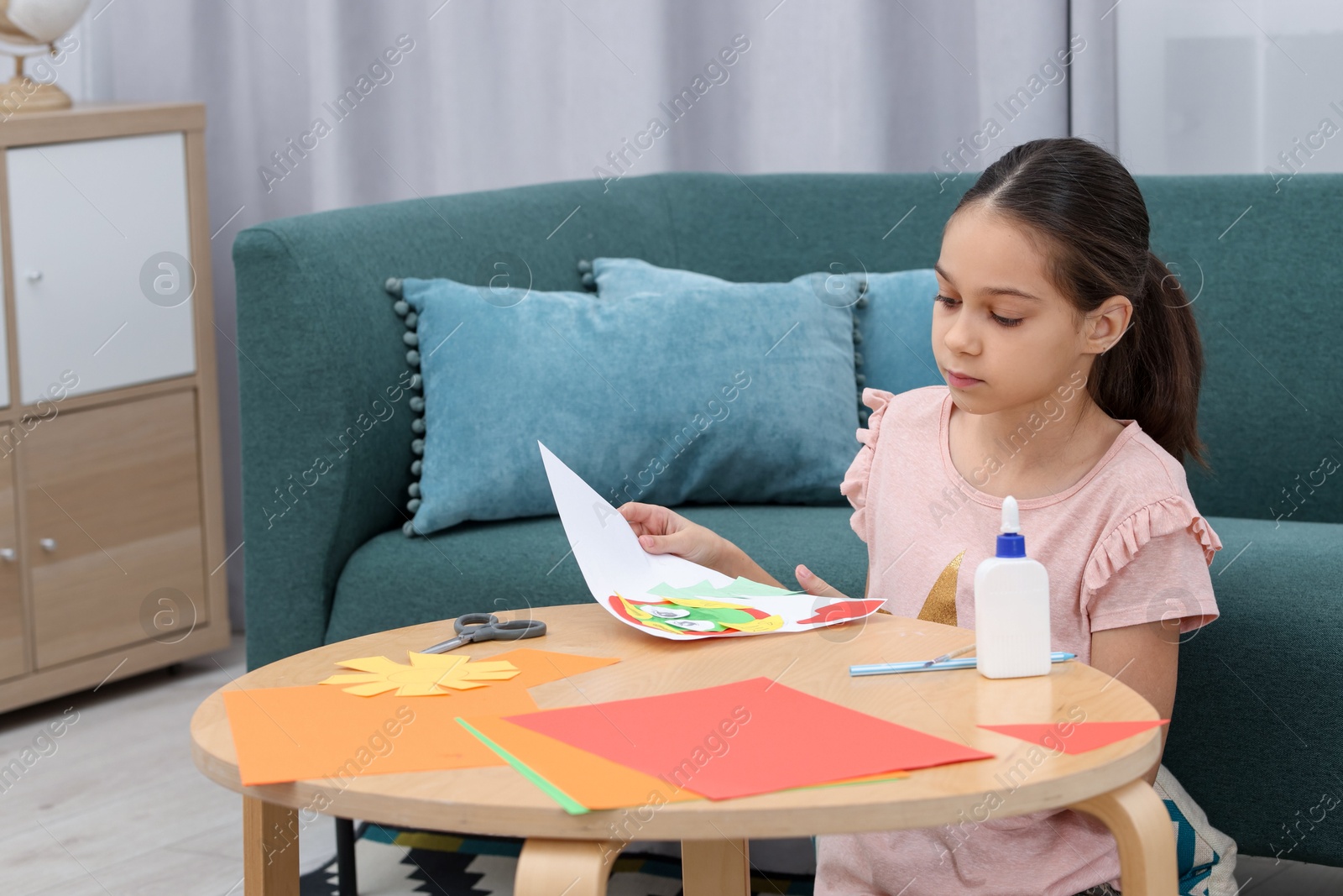 Photo of Girl making art project at table indoors