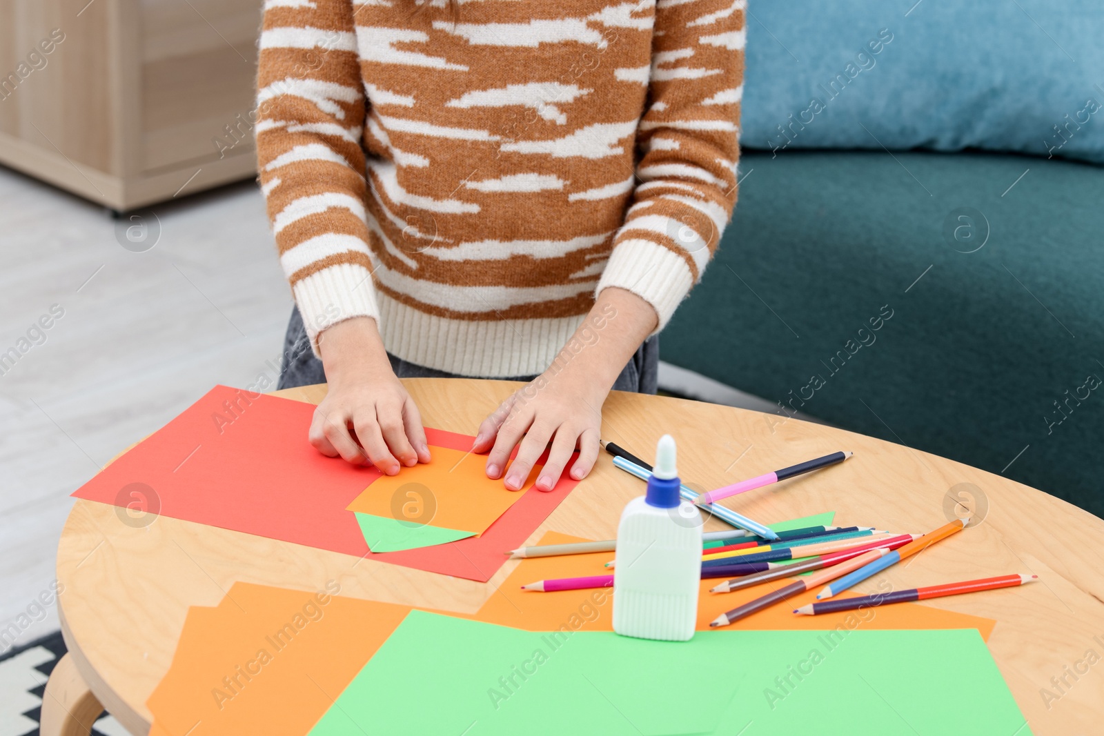 Photo of Girl making art project at table indoors, closeup