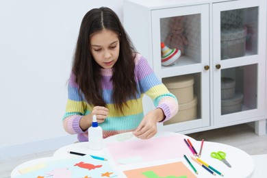 Photo of Girl making art project at table indoors