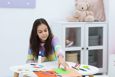 Photo of Girl making art project at table indoors