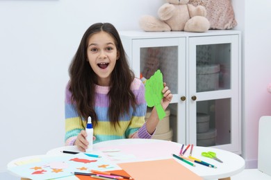 Photo of Girl making art project at table indoors