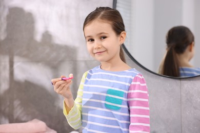 Photo of Cute girl with toothbrush in bathroom. Personal hygiene