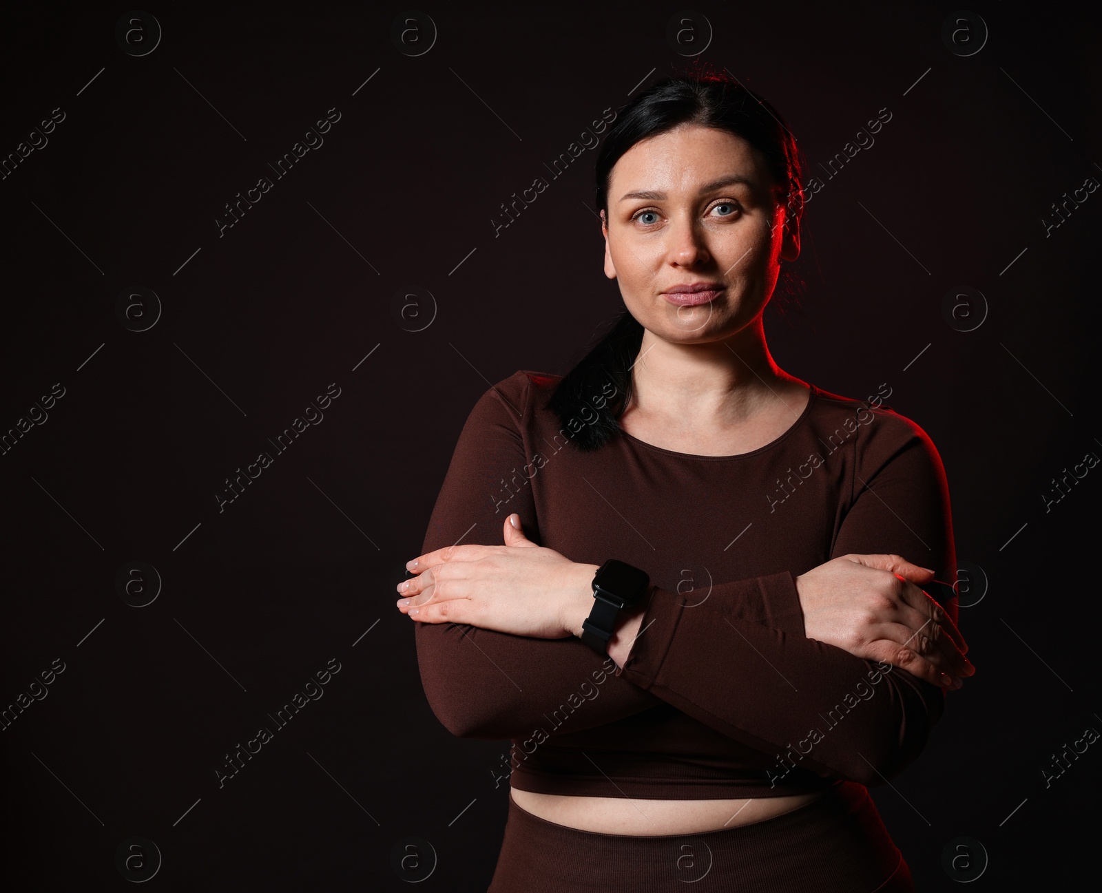 Photo of Plus size woman in gym clothes on black background, space for text