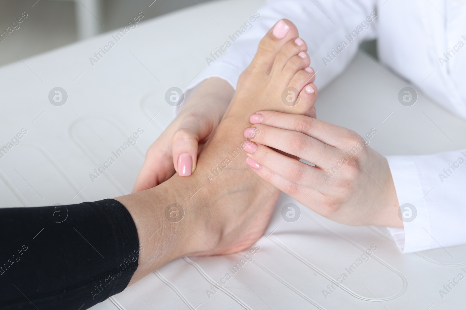 Photo of Doctor examining patient's foot in hospital, closeup