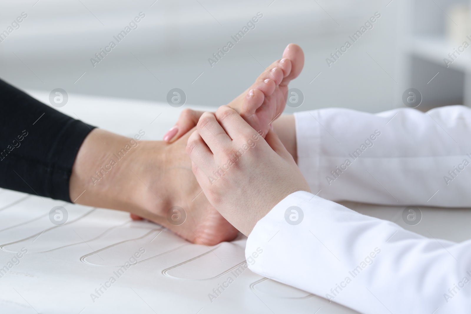 Photo of Doctor examining patient's foot in hospital, closeup