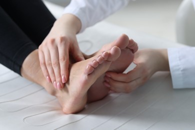 Photo of Doctor examining patient's foot in hospital, closeup