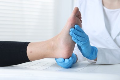 Photo of Doctor examining patient's foot in hospital, closeup