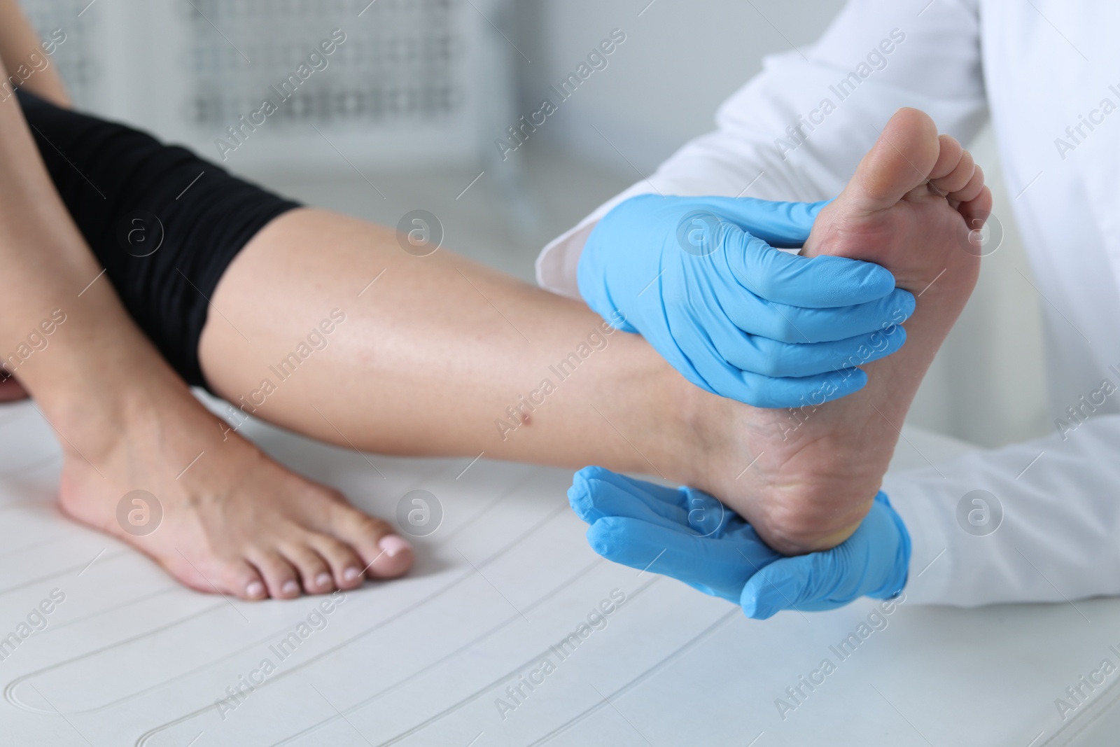 Photo of Doctor examining patient's foot in hospital, closeup