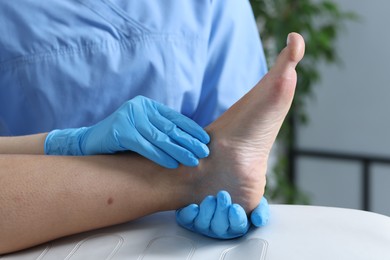 Photo of Doctor examining patient's foot in hospital, closeup