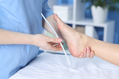 Photo of Doctor fitting insole to patient's foot in hospital, closeup