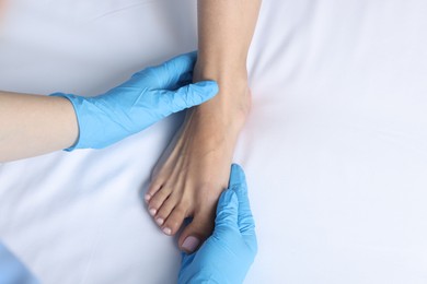 Photo of Doctor examining patient's foot in hospital, top view