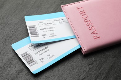 Photo of Travel agency. Flight tickets and passport on dark textured table, closeup