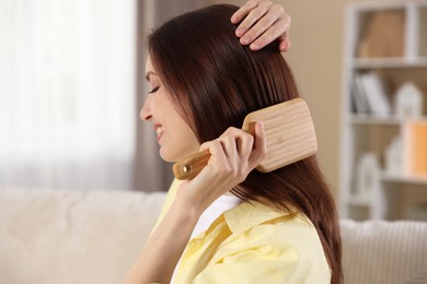 Photo of Woman brushing her beautiful hair at home