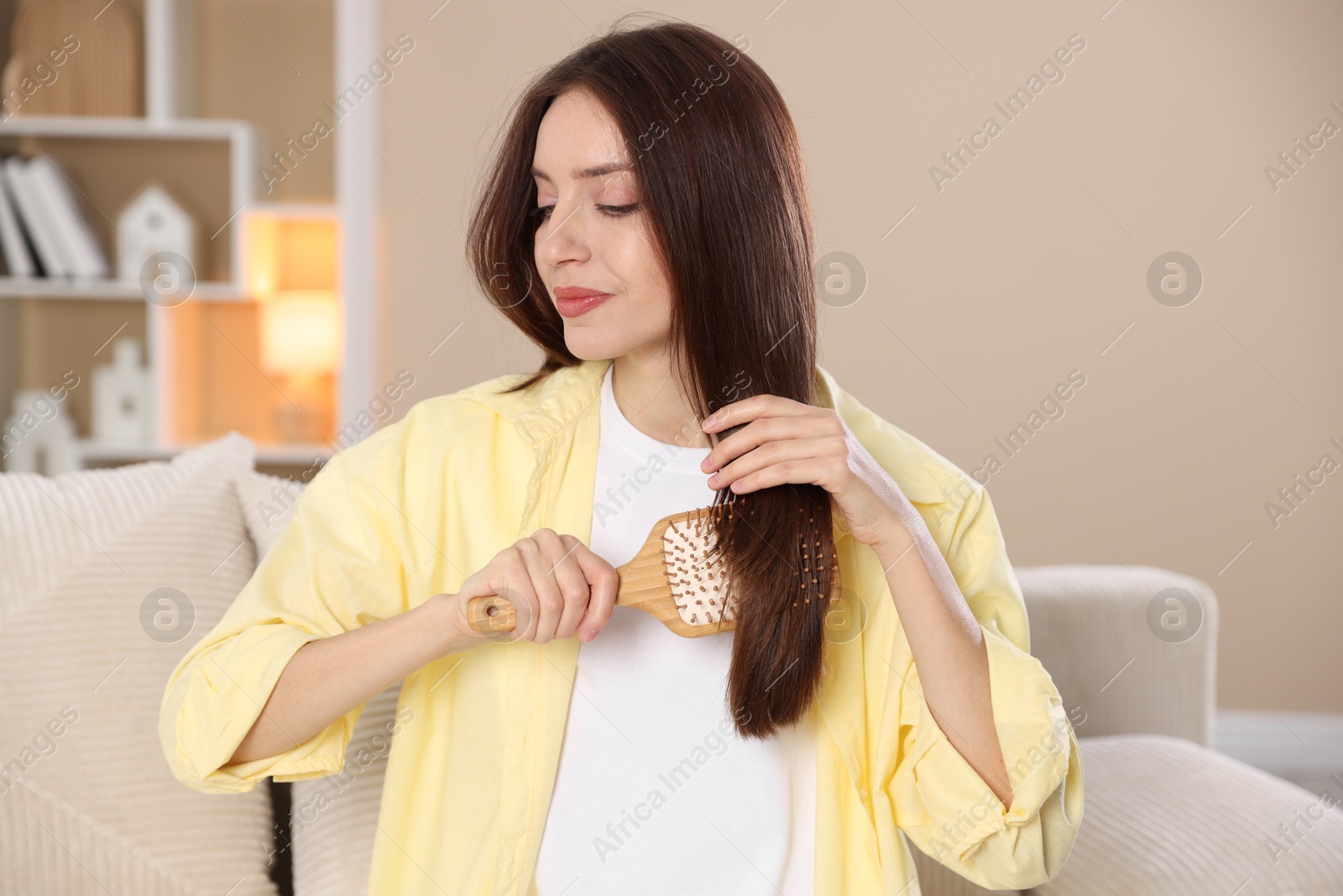 Photo of Beautiful woman brushing her hair at home