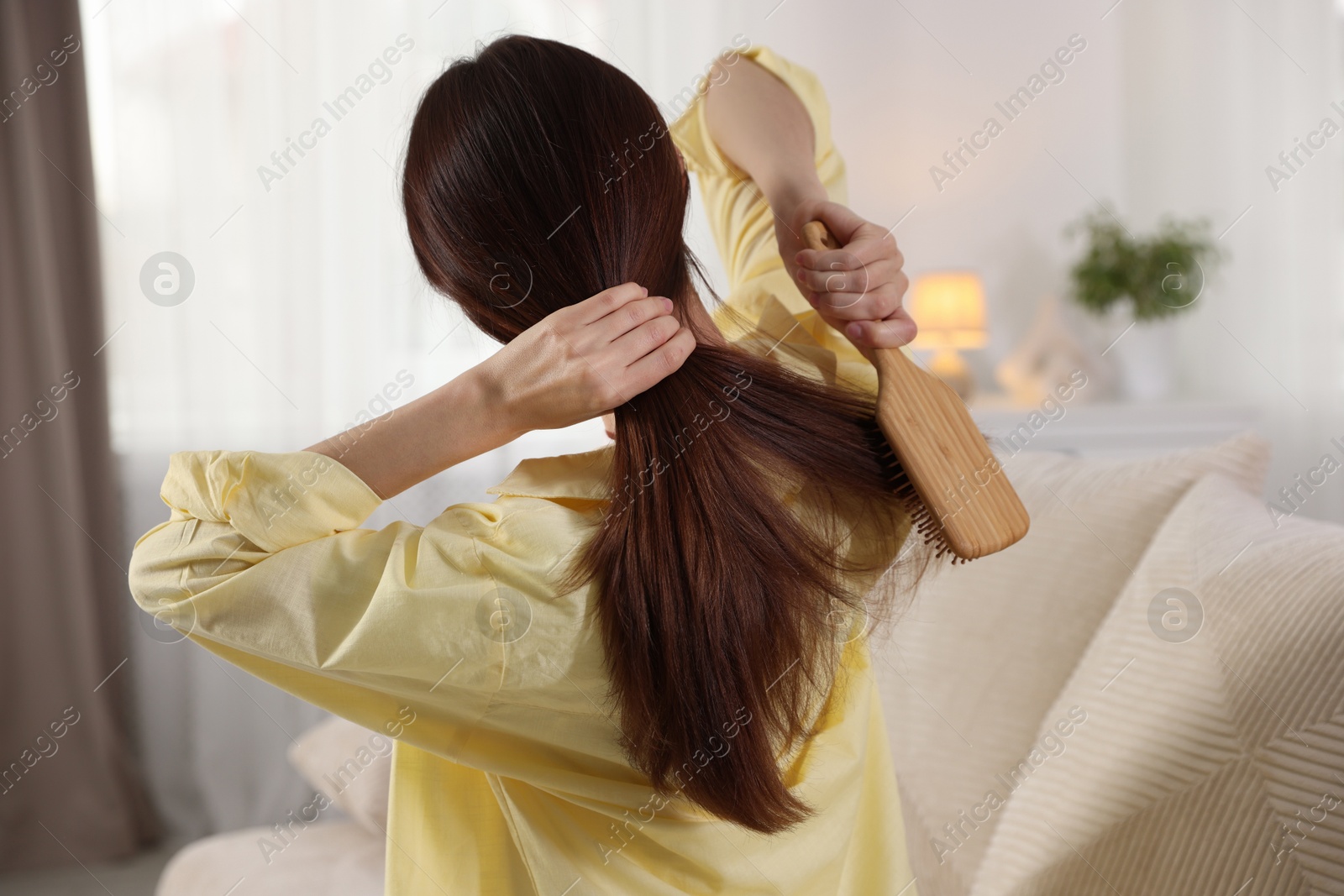 Photo of Woman brushing her beautiful hair at home