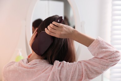 Photo of Woman brushing her beautiful hair at home