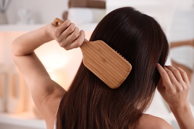 Photo of Woman brushing her beautiful hair at home