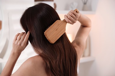 Photo of Woman brushing her beautiful hair at home