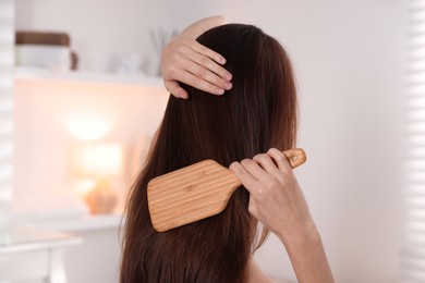 Photo of Woman brushing her beautiful hair at home