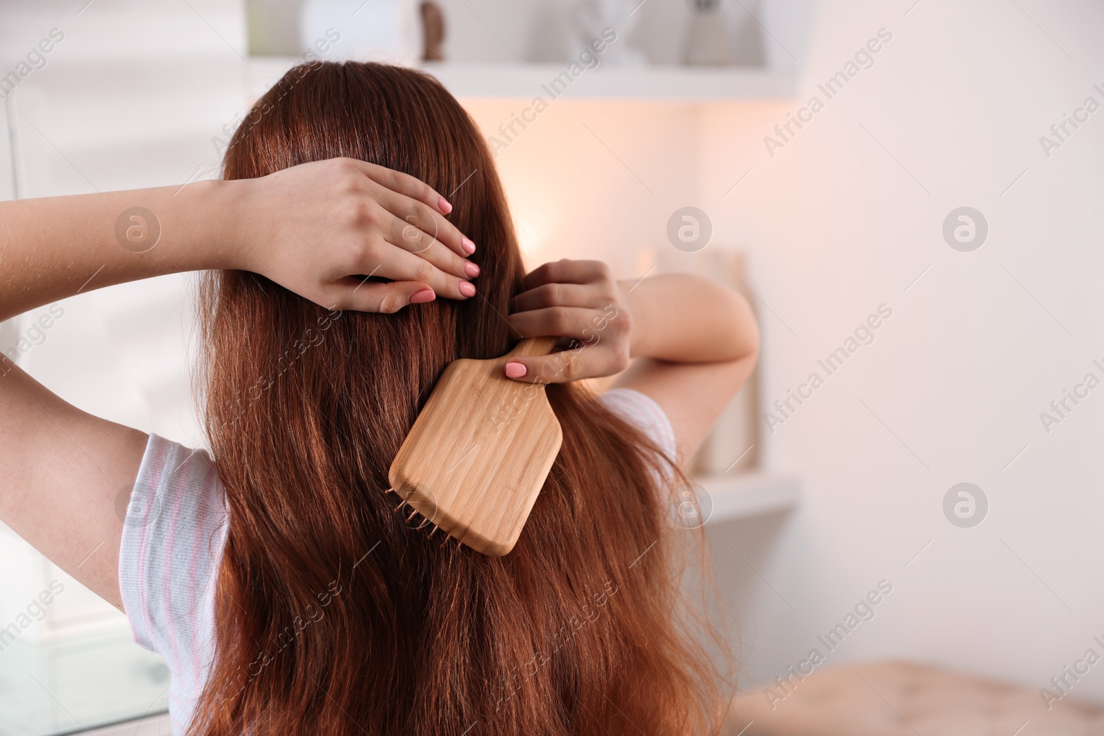 Photo of Teenage girl brushing her hair indoors, space for text