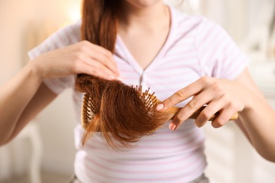 Photo of Teenage girl brushing her hair at home, closeup