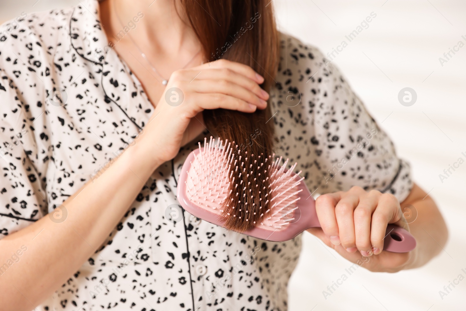 Photo of Woman brushing her hair at home, closeup