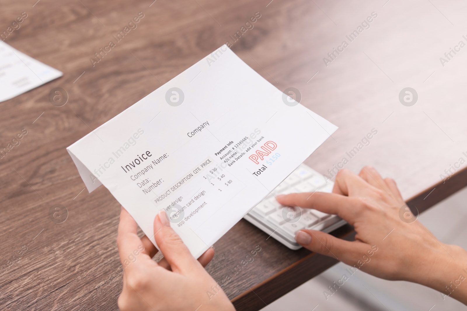 Photo of Paying bills. Woman with different invoices and calculator at wooden table indoors