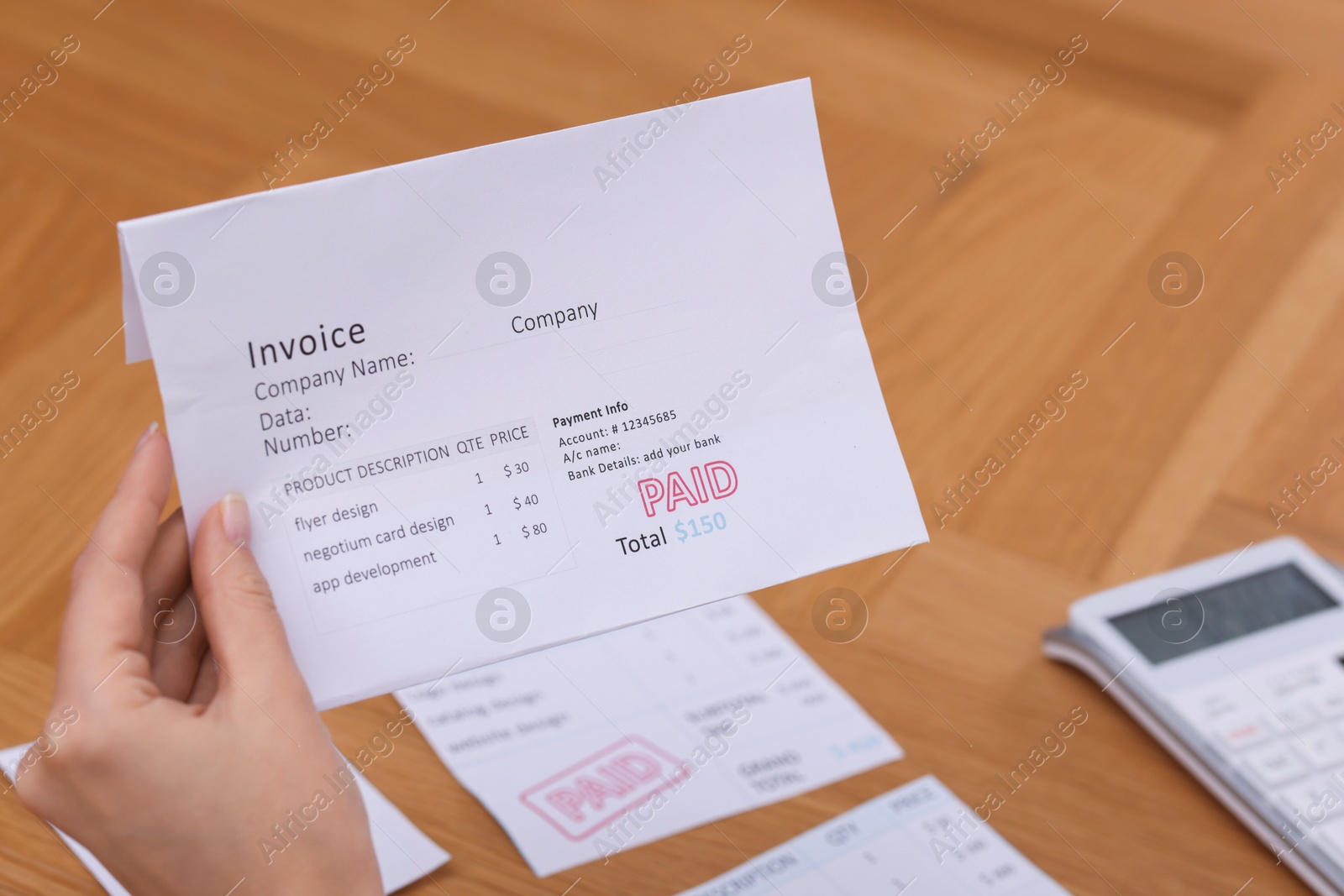 Photo of Paying bills. Woman with different invoices and calculator at wooden table indoors, closeup