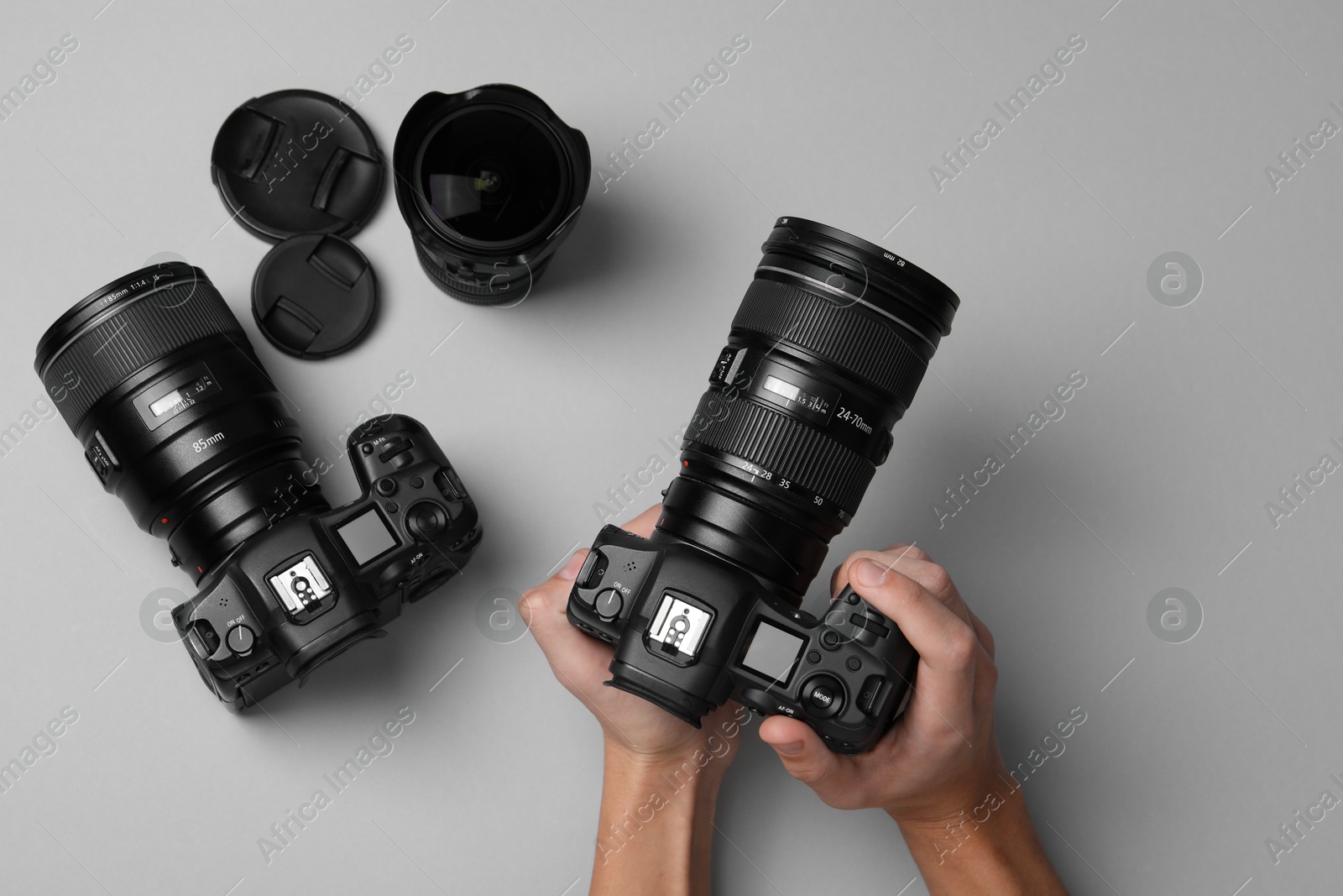 Photo of Photographer with professional camera on grey background, top view