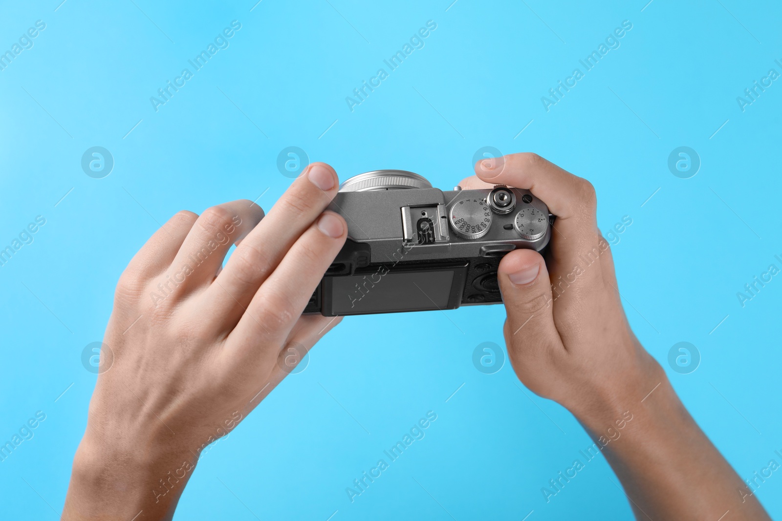 Photo of Photographer with vintage camera on light blue background, above view