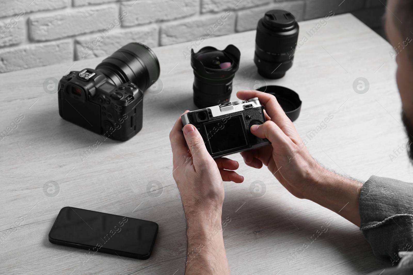 Photo of Photographer with vintage camera at wooden table, closeup