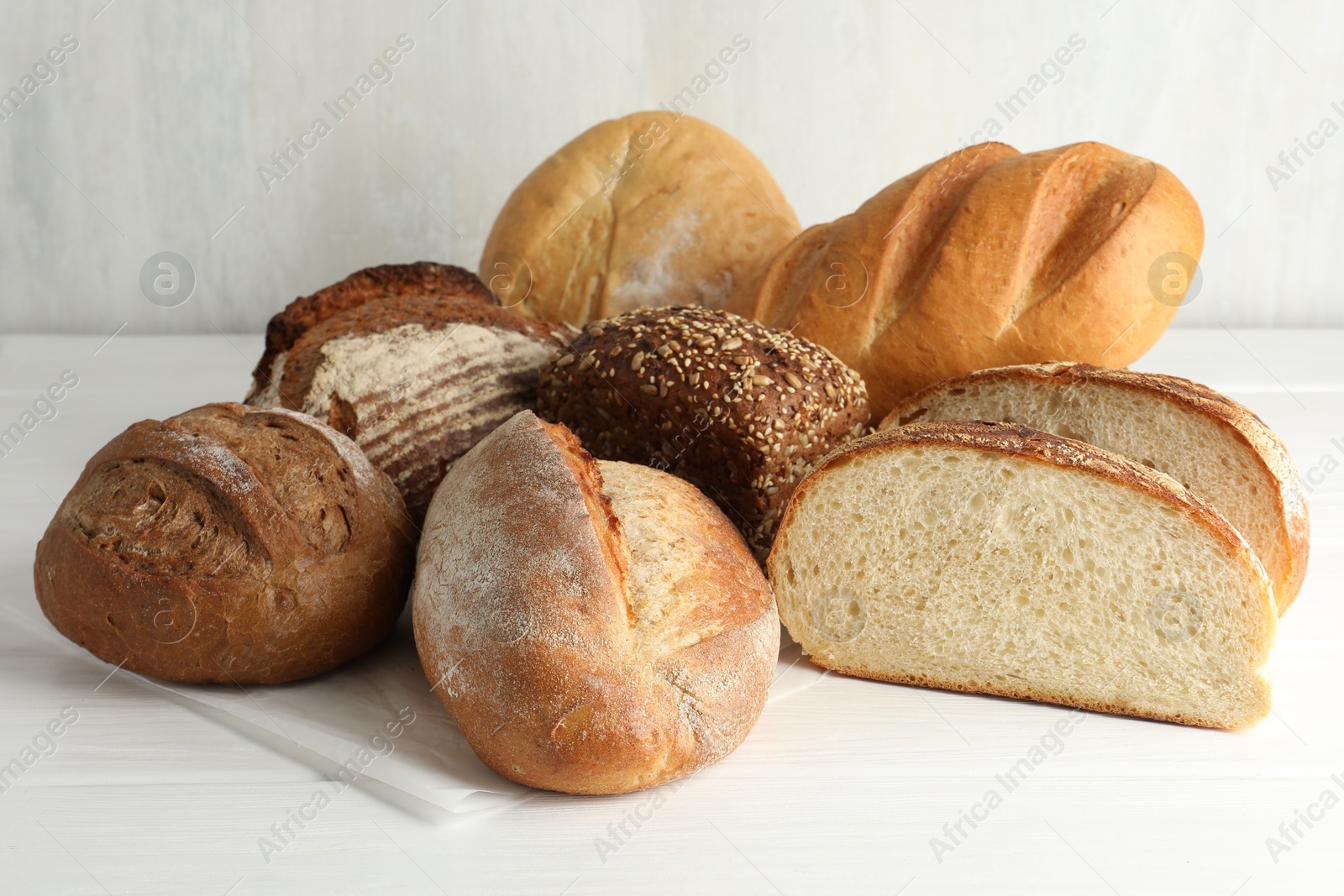 Photo of Whole and cut bread loafs on white table