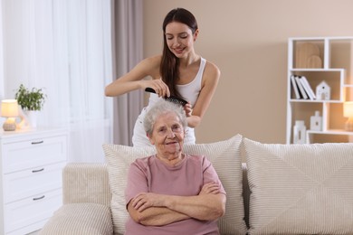 Photo of Woman brushing senior lady with comb indoors