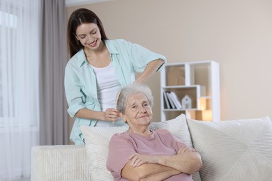 Photo of Woman brushing senior lady with brush indoors