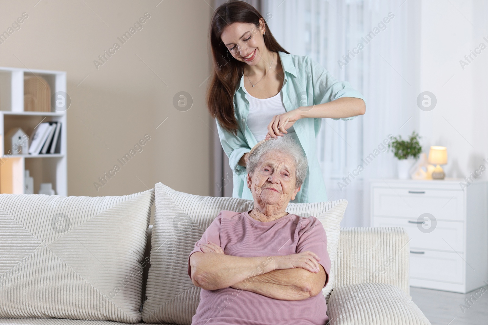 Photo of Woman brushing senior lady with brush indoors