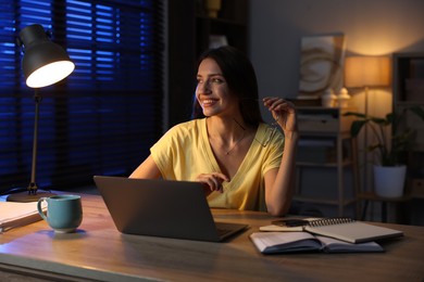 Photo of Woman working on laptop at desk in home office