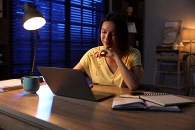 Woman working on laptop at desk in home office