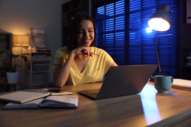 Photo of Woman working on laptop at desk in home office