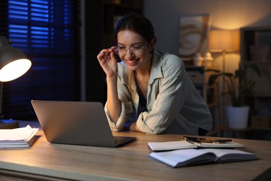 Photo of Woman working on laptop at desk in home office