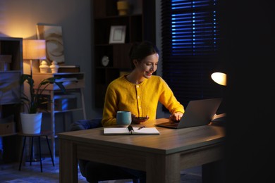 Photo of Woman working on laptop at desk in home office