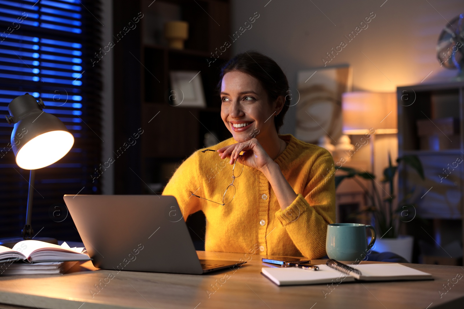 Photo of Woman working on laptop at desk in home office