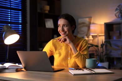 Photo of Woman working on laptop at desk in home office