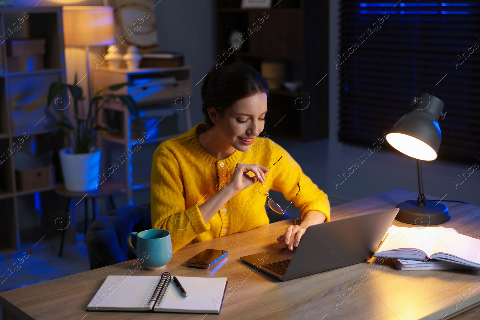 Photo of Woman working on laptop at desk in home office