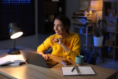 Photo of Woman working on laptop at desk in home office